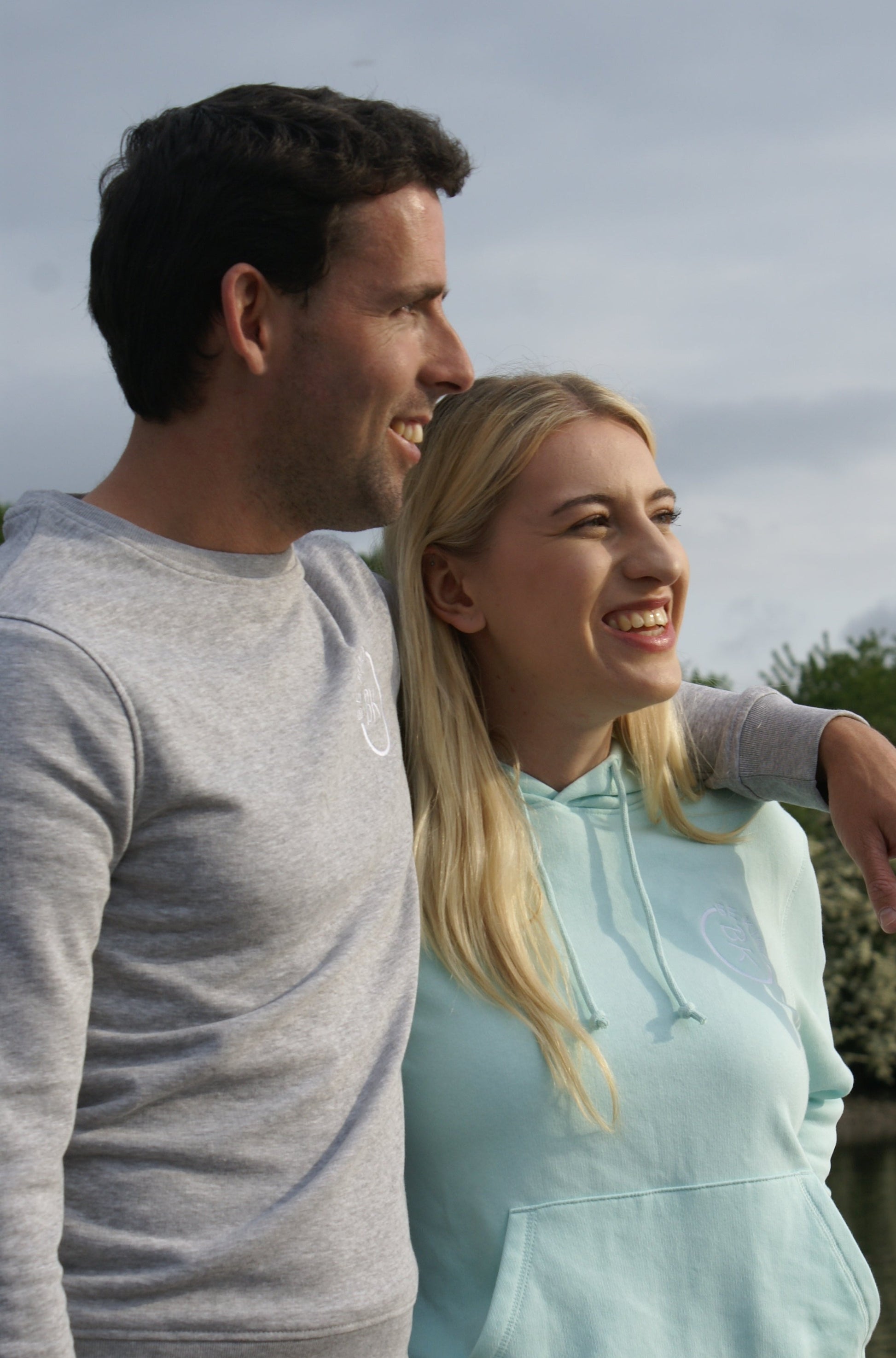 A woman laughs, she's wearing a Mint Green Organic Cotton Hoodie from the Be Kind Apparel Original Collection