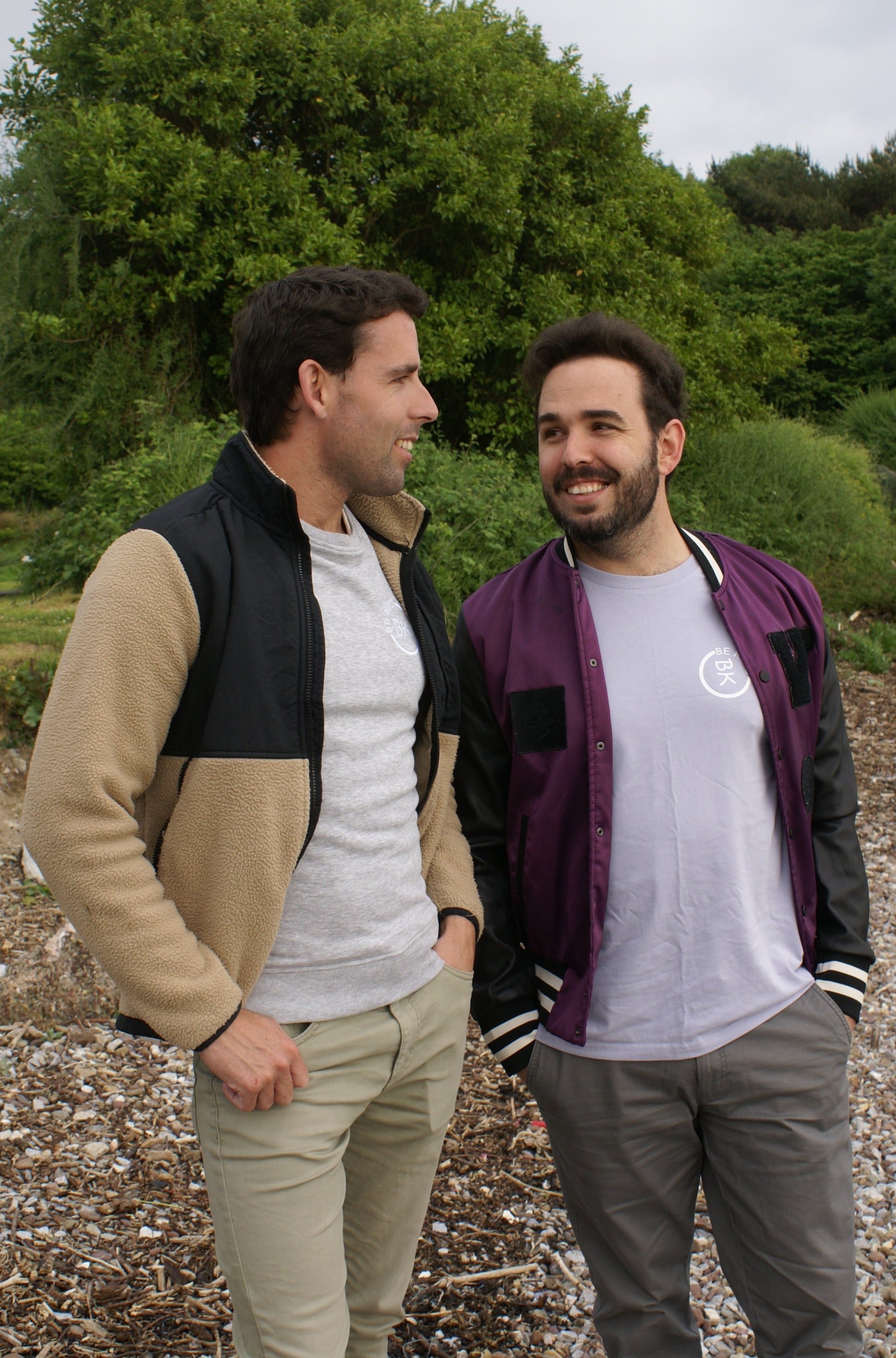 A man smiles at his boyfriend, he's wearing a Lavender Organic Cotton T-Shirt from the Be Kind Apparel Original Collection