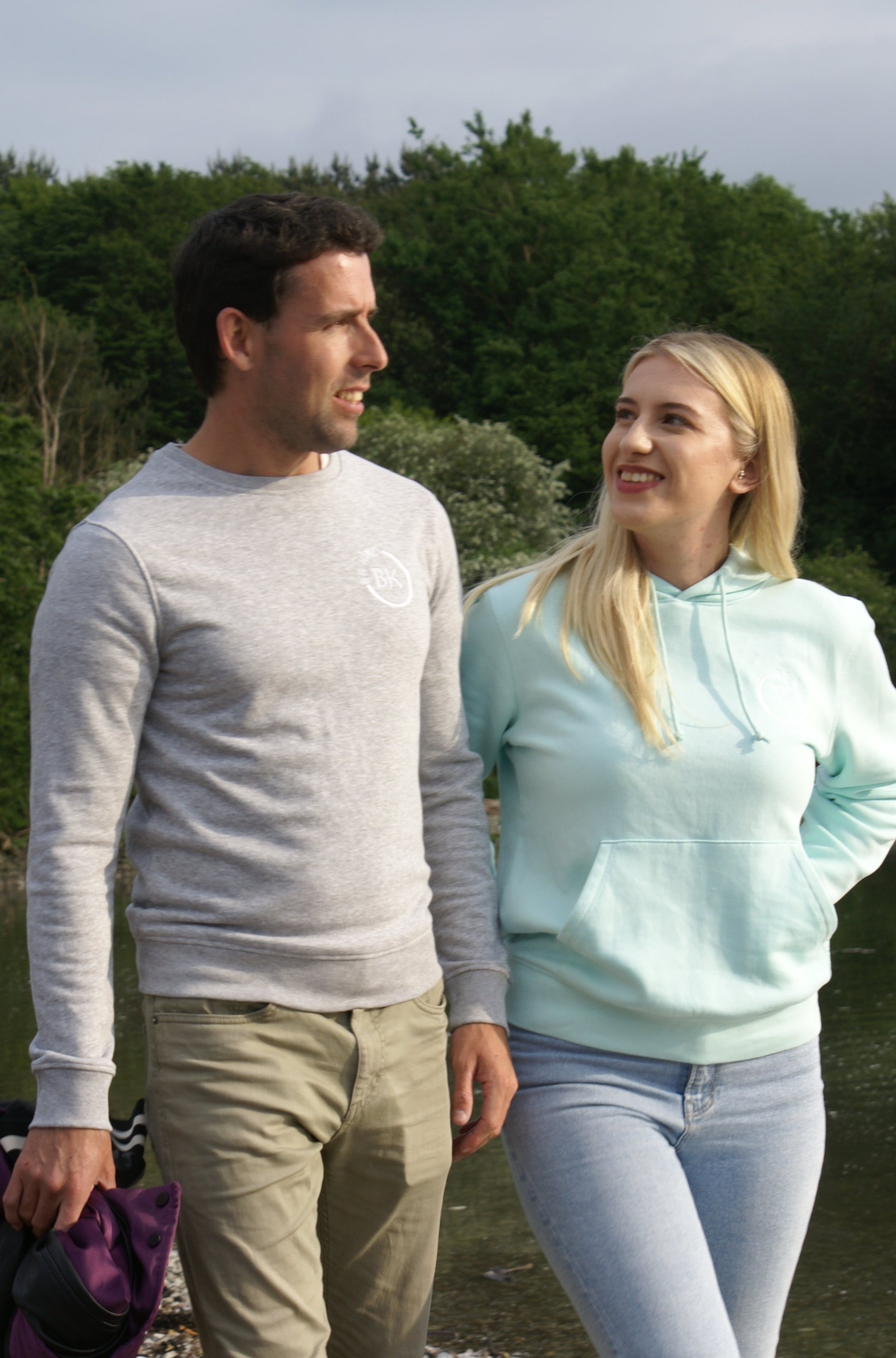 A woman looks at a man, she's wearing a Mint Green Organic Cotton Hoodie from the Be Kind Apparel Original Collection