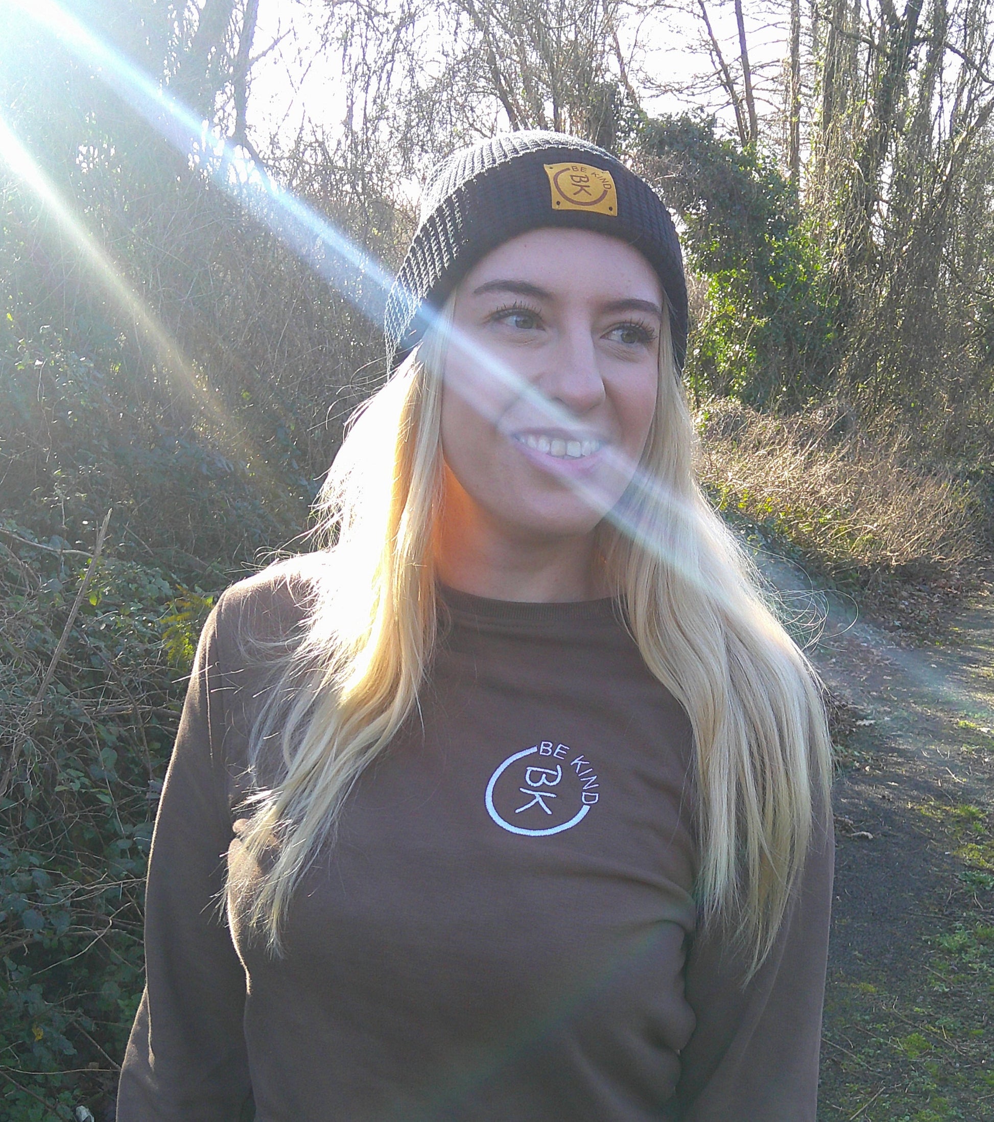 A woman looks away, she's wearing a Mustard Organic Cotton Waffle beanie from be Kind Apparel